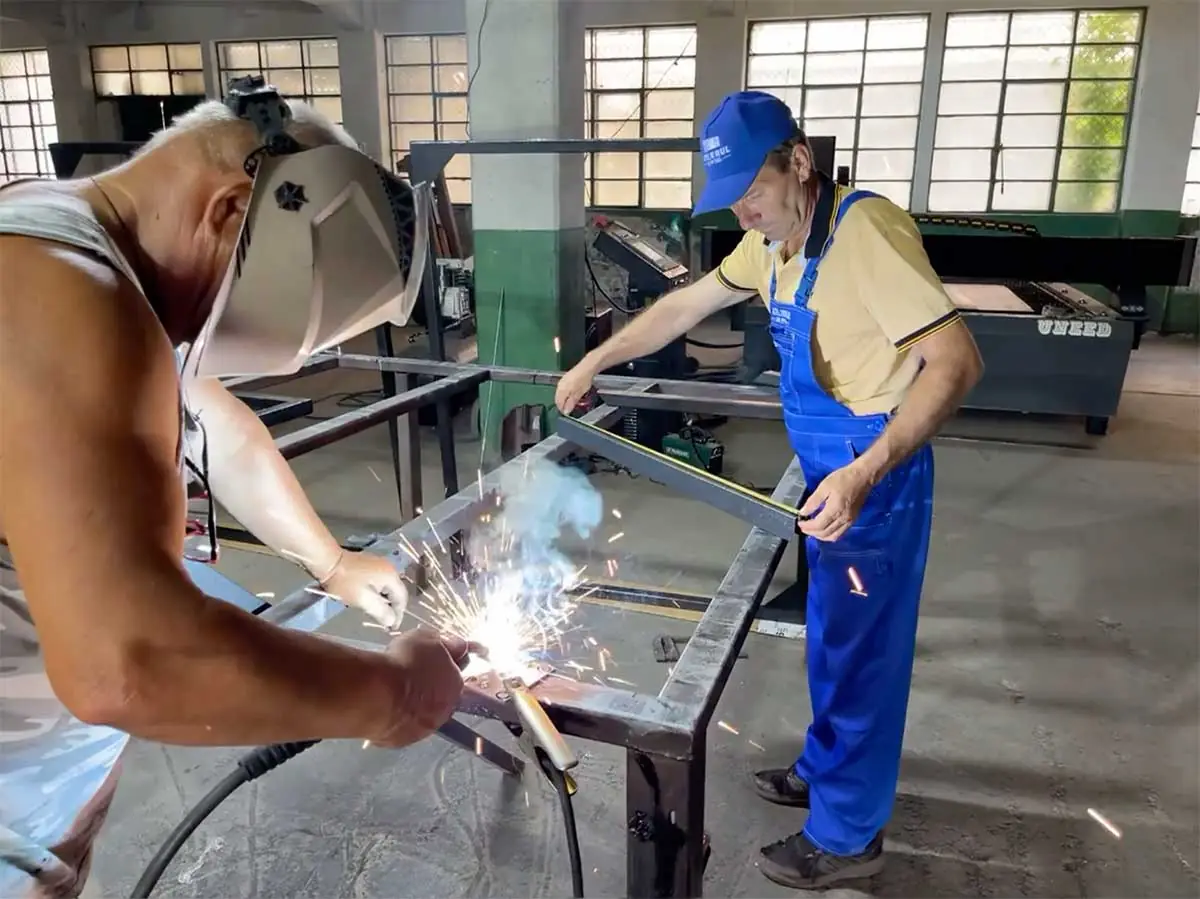 Meșteri sudând o structură metalică în atelierul din Râmnicu Sărat