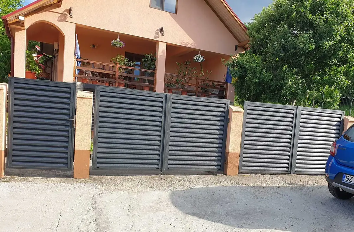 Gard metalic cu jaluzele orizontale gri antracit în fața unei case